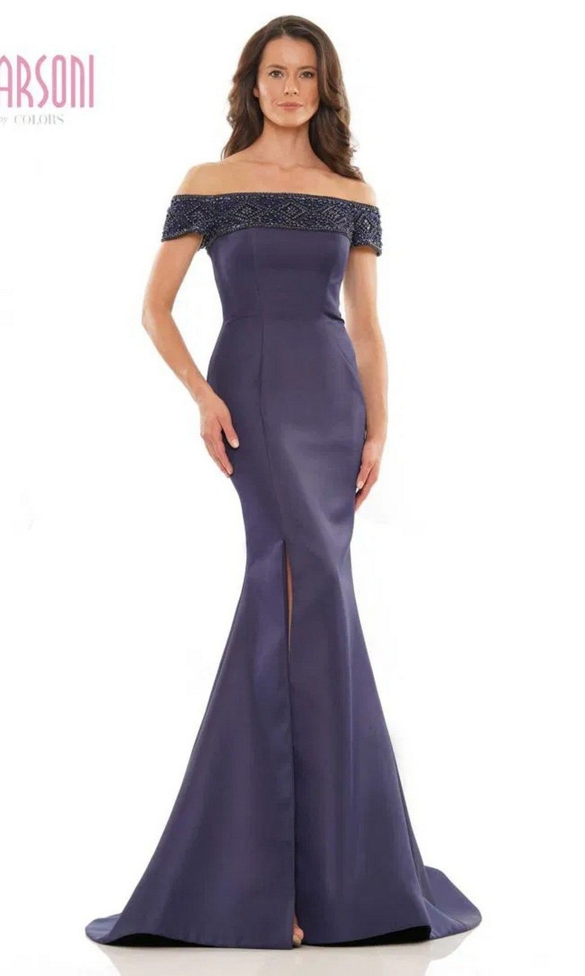 A woman faces forward in the Marsoni MV1184 long formal dress, featuring a navy, floor-length off-the-shoulder design with a beaded neckline, front slit, and elegant mermaid skirt.